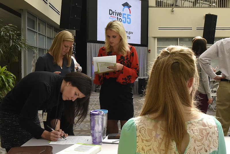 Emily Thomsen (CQ), Marissa Wood and Alex Lewis, from left, talk with Tennessee Achieves regional coordinator Meghan Woodward, right, during an event at the Unum atrium on Tuesday, Oct. 28, 2015, in Chattanooga, Tenn. The event was held to encourage Unum employees to sign up to be mentors to help with Tennessee Promise and Tennessee Achieve. 
