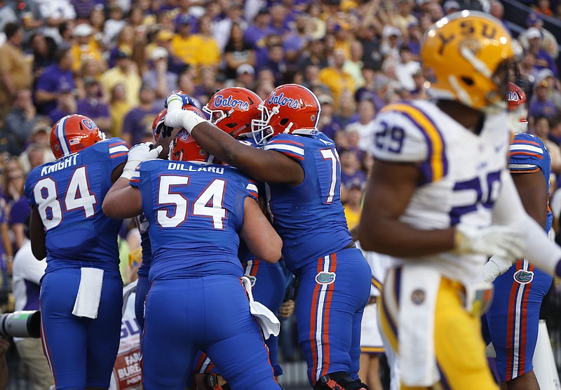 
              FILE - In this Oct. 17, 2015, file photo, Florida tight end Jake McGee is hugged by teammates after catching a touchdown pass in the first half of an NCAA college football game against LSU in Baton Rouge, La., Saturday, Oct. 17, 2015. If the Gators win Saturday against rival Georgia, they would just need to beat Vanderbilt or South Carolina down the stretch to get to Atlanta and the SEC Conference Championship for the first time since 2009. (AP Photo/Gerald Herbert, File)
            