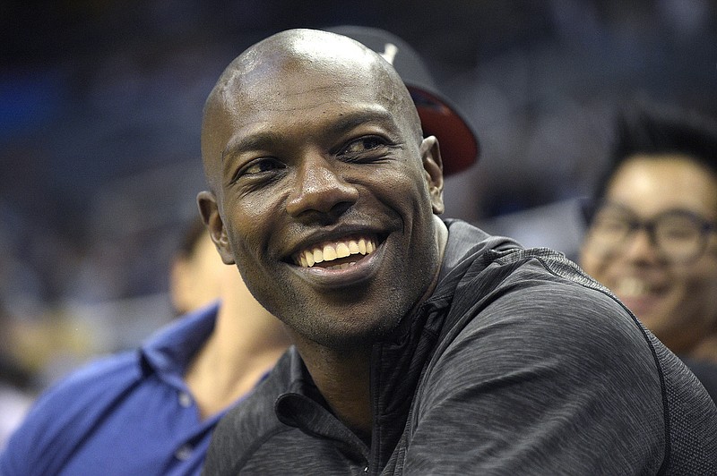 Former NFL football player Terrell Owens watches the action from court side seats during a game between the Orlando Magic and the Memphis Grizzlies in Orlando, Fla., in this Oct. 23, 2015, file photo. 