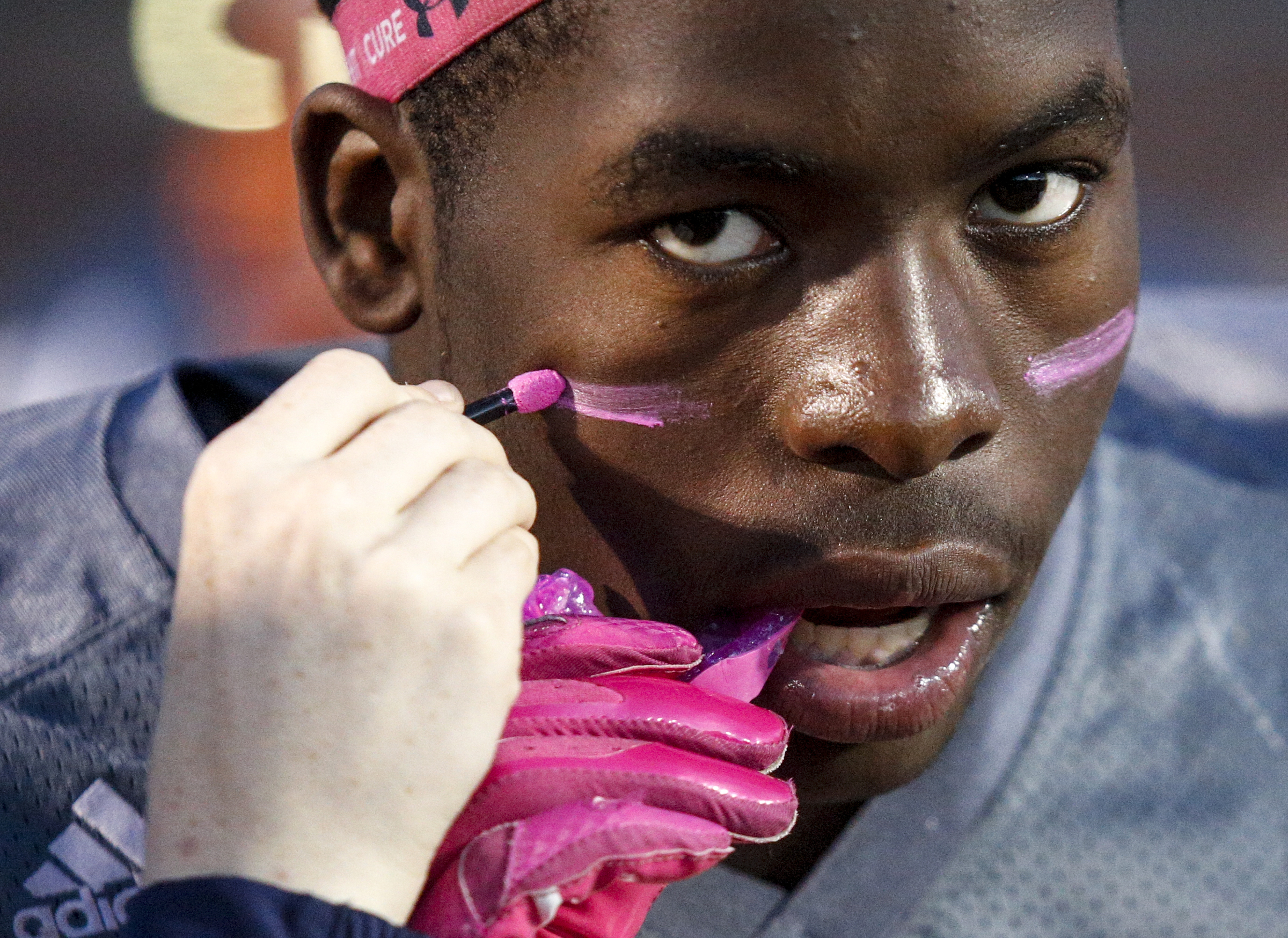 East Ridge player Lorenzo Stewart has pink liner applied to his face before their prep football game against CCS at East Ridge High School on Friday, Oct. 30, 2015, in East Ridge, Tenn.