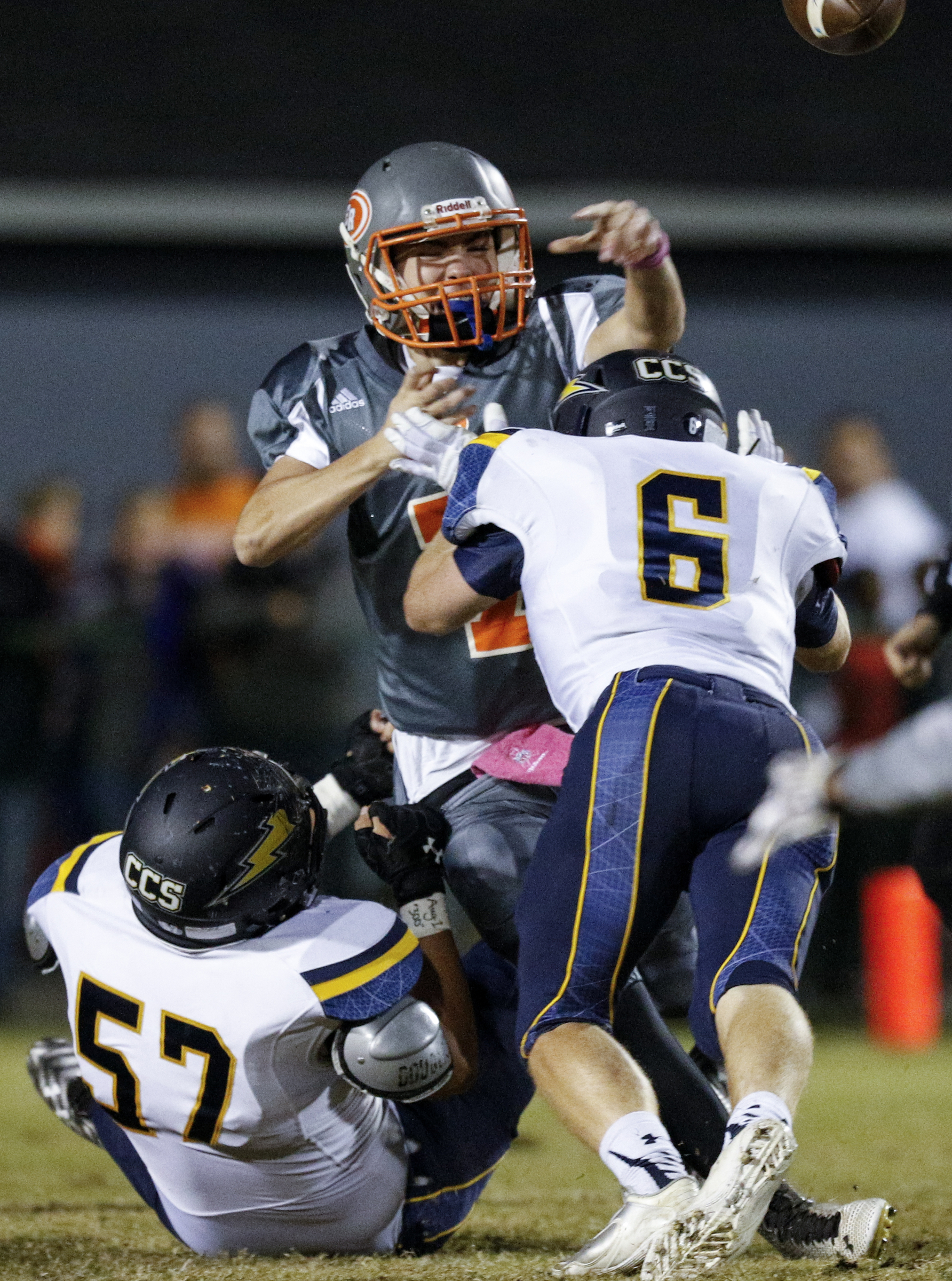 East Ridge quarterback Eric Bennett is hit as he passes by CCS defenders Justin Wheeler (6) and Michael Nelson (57) during their prep football game at East Ridge High School on Friday, Oct. 30, 2015, in East Ridge, Tenn.