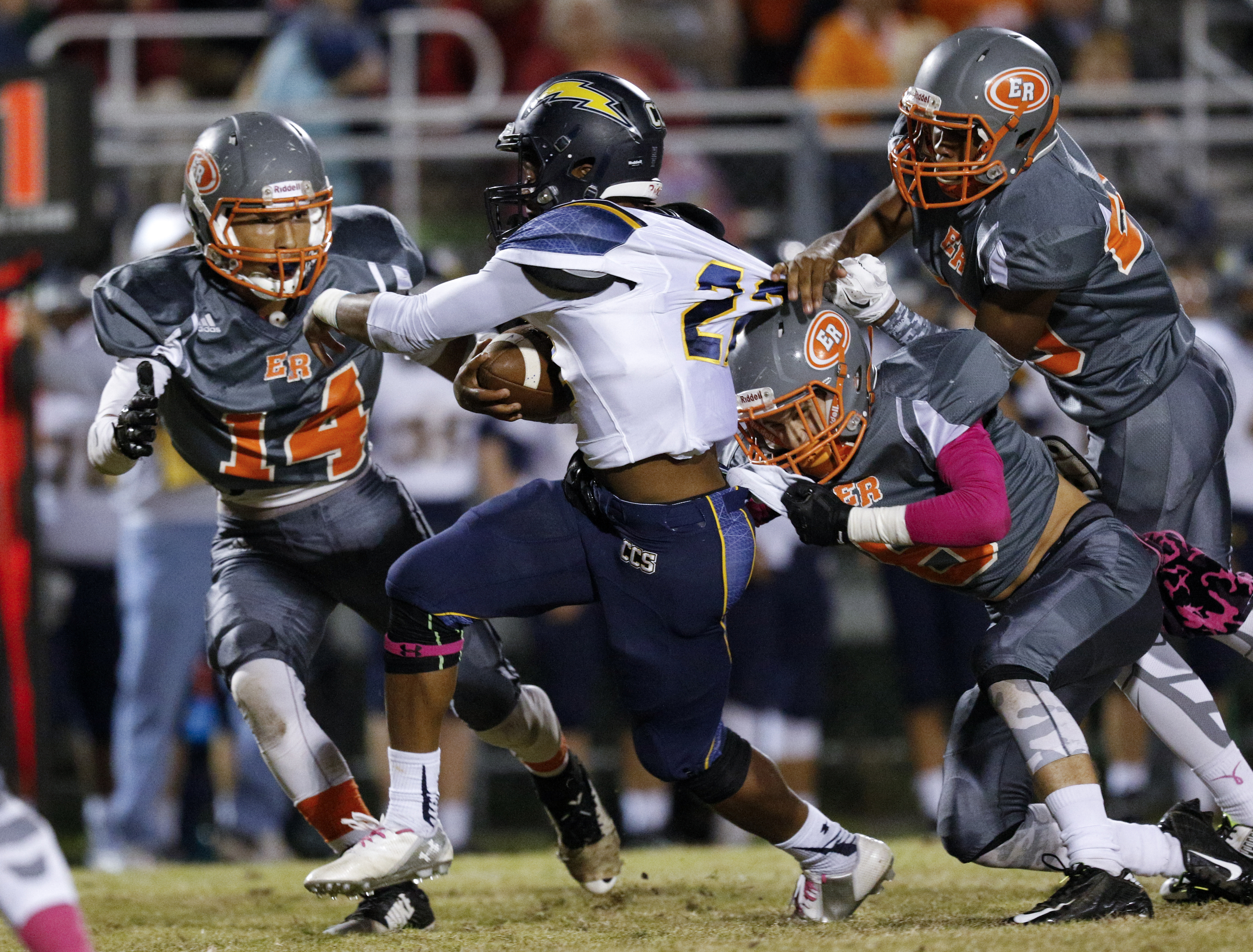 CCS running back T.J. Smith struggles against East Ridge defenders Jordan Harvey (14), B.J. Church, right, and Josh Williams during their prep football game at East Ridge High School on Friday, Oct. 30, 2015, in East Ridge, Tenn.