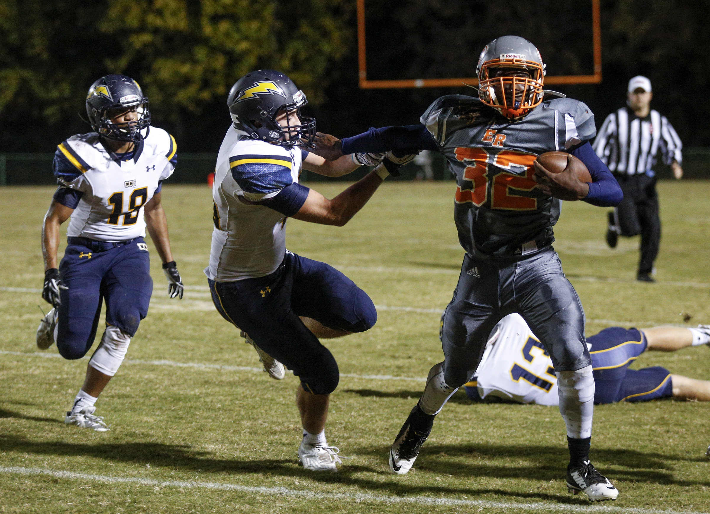 East Ridge running back Traneil Moore stiff-arms Chattanooga Christian School defender Nick Fulmer during Friday night's game at Raymond James Stadium. Moore scored three touchdowns as the Pioneers won 28-13 to finish the regular season undefeated and head to the state playoffs as Region 3-3A champions.