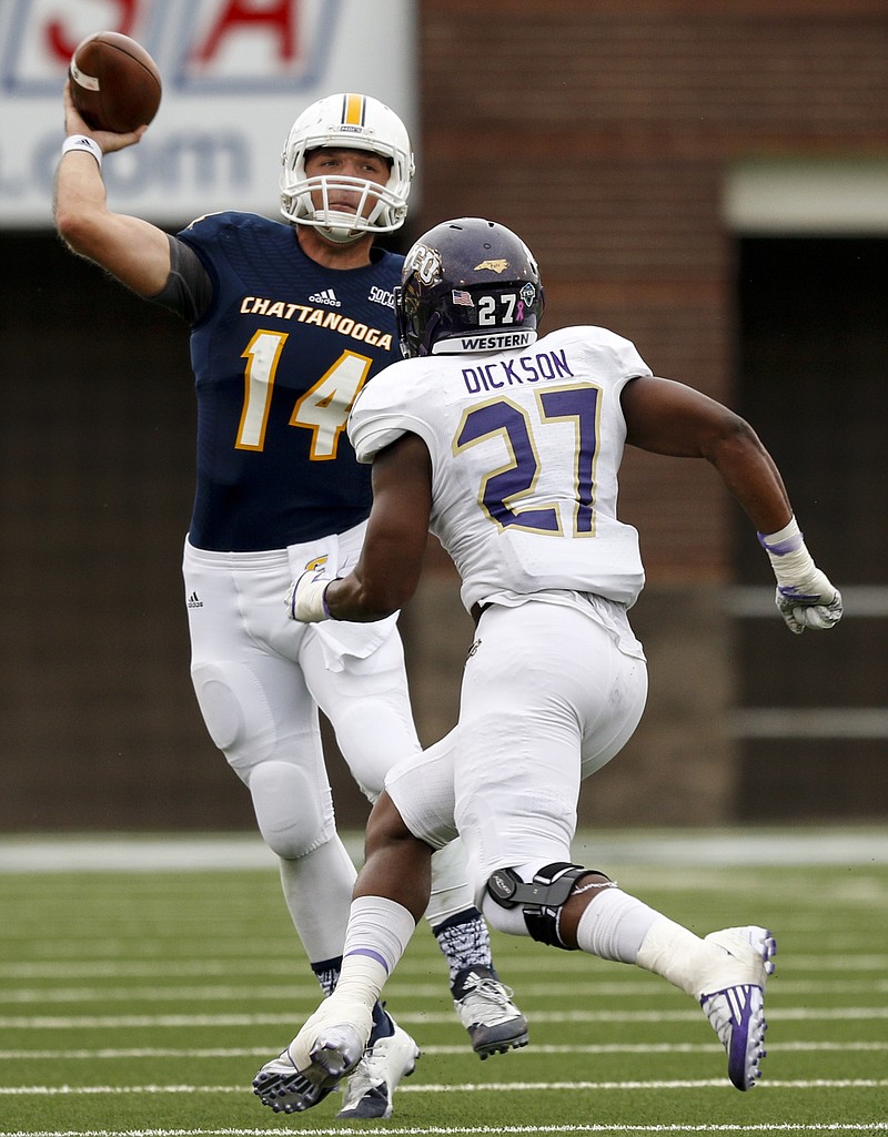 UTC quarterback Jacob Huesman (14) passes under pressure from Western Carolina linebacker Tyson Dickson during the Mocs' SoCon football game against Western Carolina at Finley Stadium on Saturday, Oct. 31, 2015, in Chattanooga, Tenn.