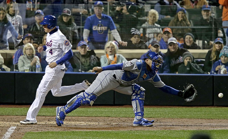 
              New York Mets' Wilmer Flores, right, scores past Kansas City Royals catcher Salvador Perez on a sacrifice fly ball by Curtis Granderson during the third inning of Game 4 of the Major League Baseball World Series Saturday, Oct. 31, 2015, in New York.(AP Photo/Peter Morgan)
            
