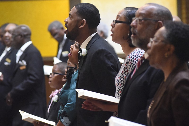 Rev. Dr. Ernest L. Reid, Jr., center, stands with his family and sings a hymn during a service where he was welcomed as the new pastor of the Second Missionary Baptist Church on Sunday, Oct. 18, 2015, in Chattanooga. The church recently celebrated 149 years in operation and he is the 21st pastor in the church's history. 