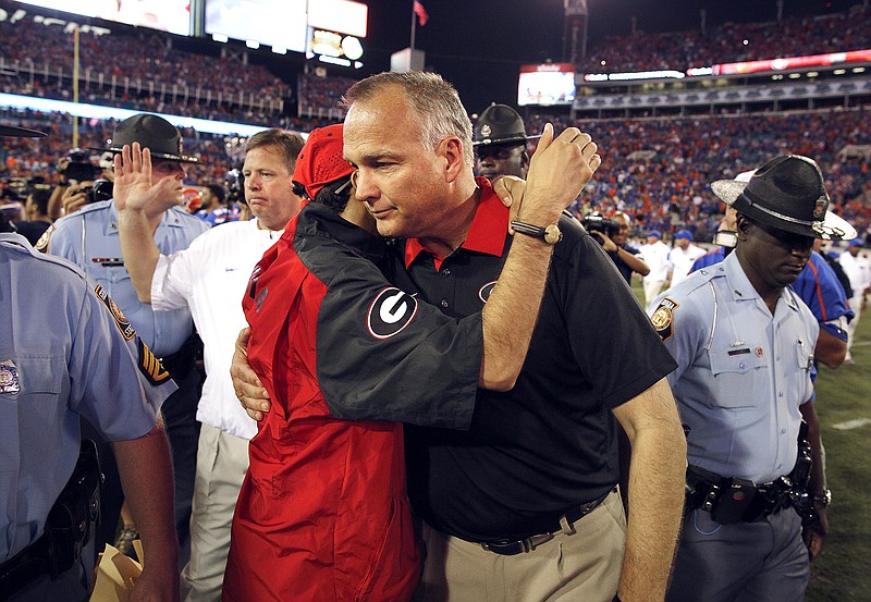 Georgia head coach Mark Richt hugs his son Zack at the end of a NCAA college football game against Florida on Saturday, Oct. 31, 2015, in Jacksonville, Fla. Florida defeated Georgia 27-3.