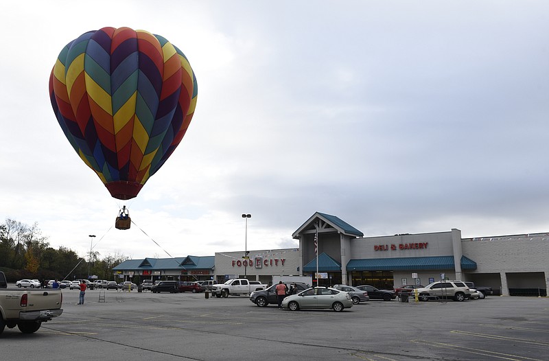 Passengers go up for a tethered balloon ride in the parking lot of the Food City grocery store in the St. Elmo community on Wednesday, Nov. 4, 2015, in Chattanooga, Tenn. Hot air balloons were scheduled to be launched at 22 Food City locations in the Chattanooga area on Wednesday to announce grand opening celebrations for the grocery chain that took over local Bi-Lo stores. 