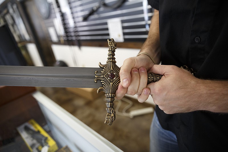 President Chris Beasley holds a replica of the sword Oathkeeper, from the television show Game of Thrones, at JALIC Blades on Tuesday, Nov. 3, 2015, in Red Bank, Tenn. The company, whose name is an acronym for Just a Little Internet Company, sells swords, daggers, and sci-fi and fantasy replicas.