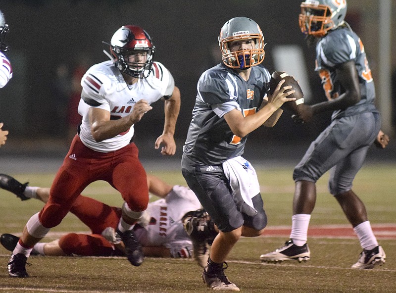 East Ridge quarterback Eric Bennett scrambles out of the pocket as he looks for a reciever.  The East Ridge Pioneers hosted the Signal Mountain Eagles at Baylor School in TSSAA football action on Friday September 4, 2015.