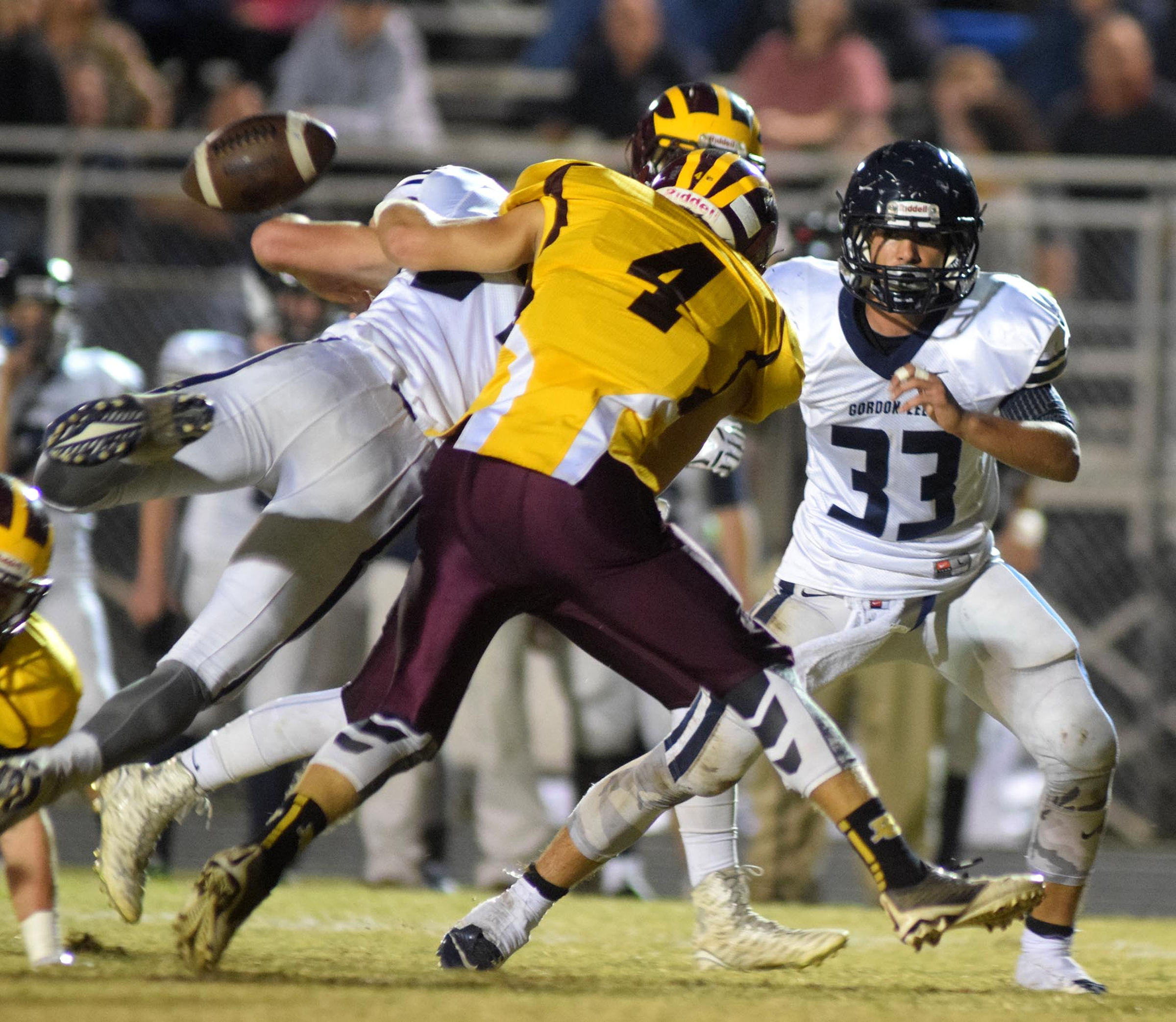 Gordon Lee's Aaron McCurdy (21) fumbles as he is hit by Dade County's Lee Spencer (4) and other members of the Wolverine defense.  The Gordon Lee Trojans visited the Dade County Wolverines in GHSA football action Thursday night, November 5, 2015.