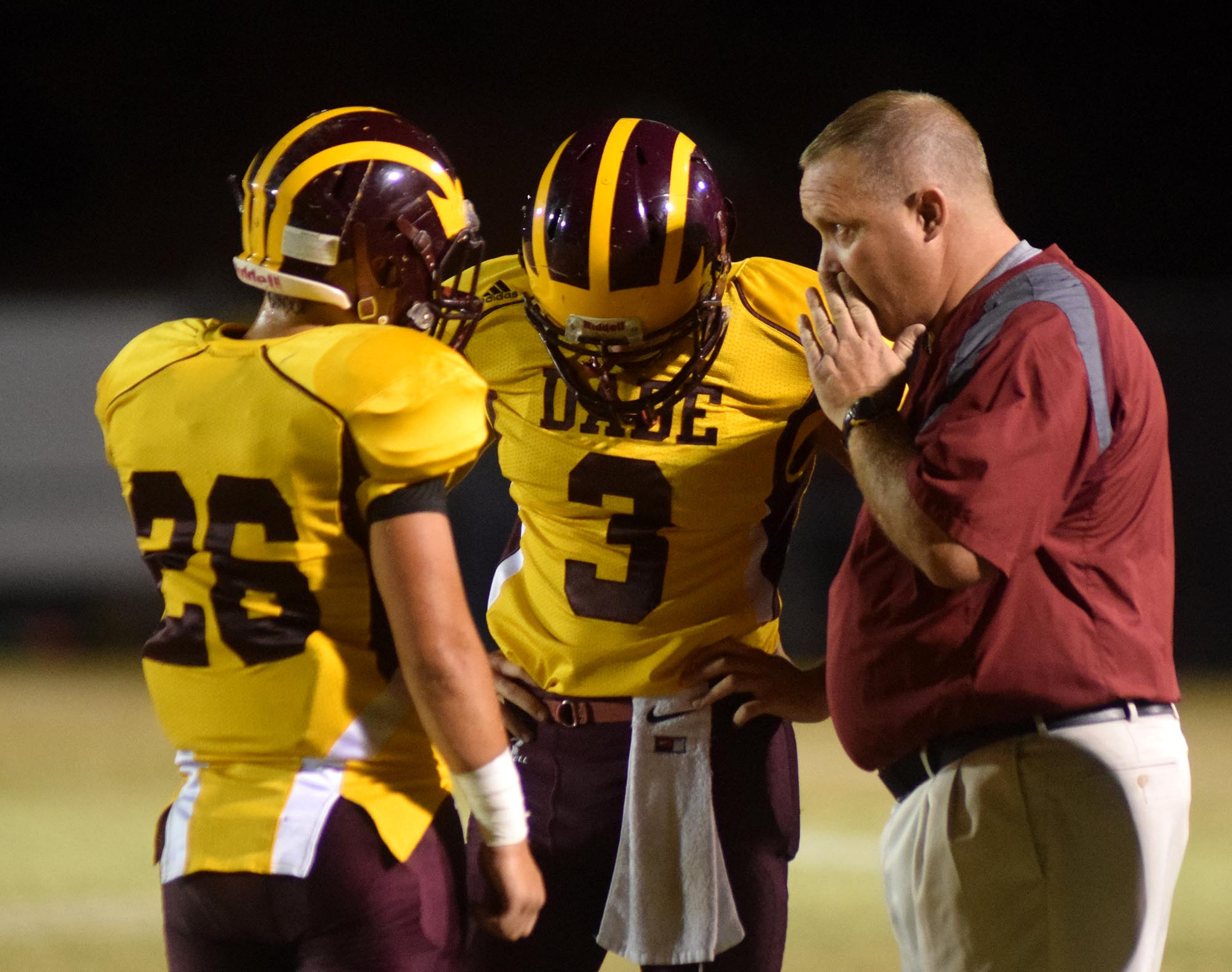 Dade County head coach Bradley Warren calls the plays as quarterback Houston Poston (3) and receiver Robert Eastman (26) listen.  The Gordon Lee Trojans visited the Dade County Wolverines in GHSA football action Thursday night, November 5, 2015.