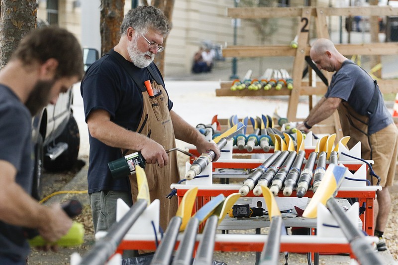 Staff Photo by Dan Henry / The Chattanooga Times Free Press- 11/5/15. Bob Snow with Concept 2 out of Morrisville, Vermont, center, removes sleeves while repairing oars in preparation for this weekends Head of the Hooch regatta in downtown Chattanooga on November 5, 2015.