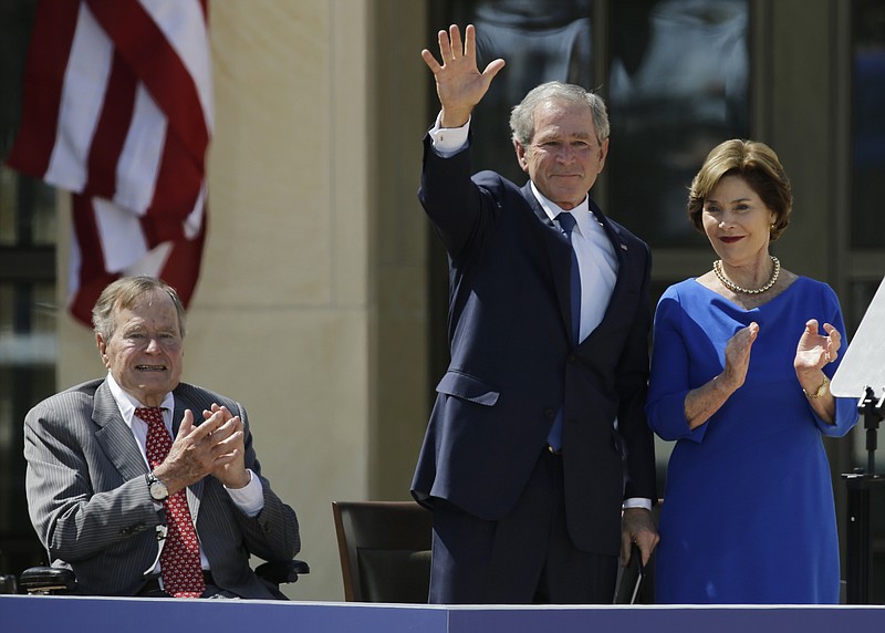 
              FILE - In this April 25, 2013, file photo, Former President George H.W. Bush, left, applauds with Laura Bush after former President George W. Bush's speech during the dedication of the George W. Bush Presidential Center in Dallas. Former President George H.W. Bush is publicly criticizing for the first time key members of his son's administration. A biography of the nation's 41st president to be published in November, 2015, contains his sharply critical assessments of former Vice President Dick Cheney and Defense Secretary Donald Rumsfeld. (AP Photo/David J. Phillip, File)
            