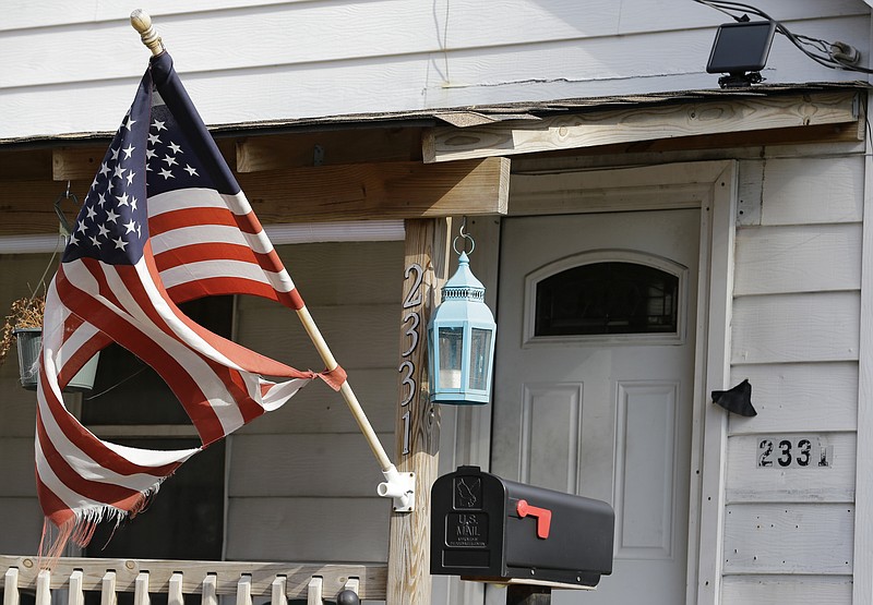 A tattered flag flies in front of a home where Julian Hernandez lived with his father, Bobby Hernandez, Thursday, Nov. 5, 2015, in Cleveland, Ohio. 
