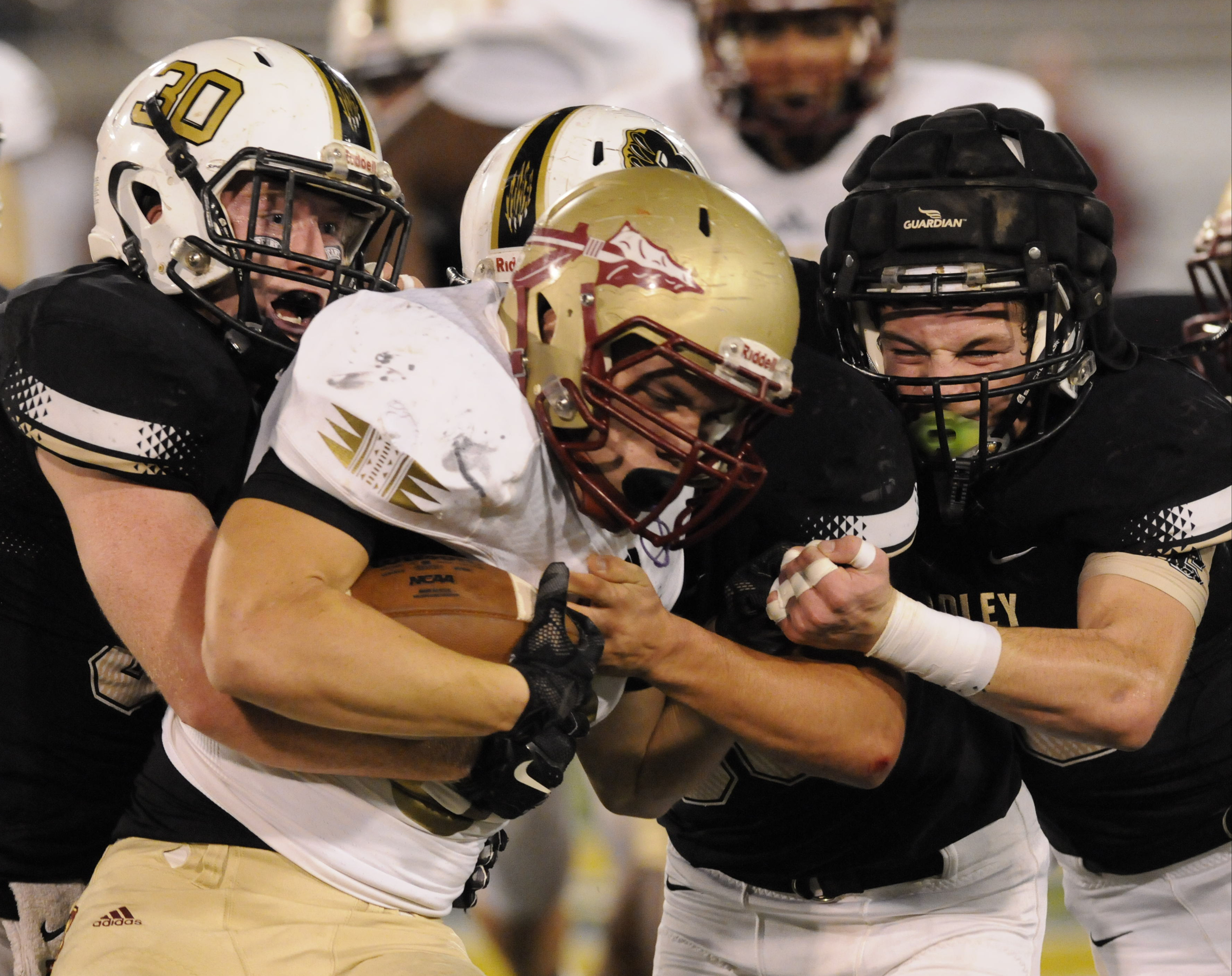 Riverdale's Austin Bryant, center, is hit tackled by Bradley Central's Colby Alford (30) and Jake Pressley, right, for short yardage Thursday night during the class 6A first-round prep football playoff game at Finley Stadium.