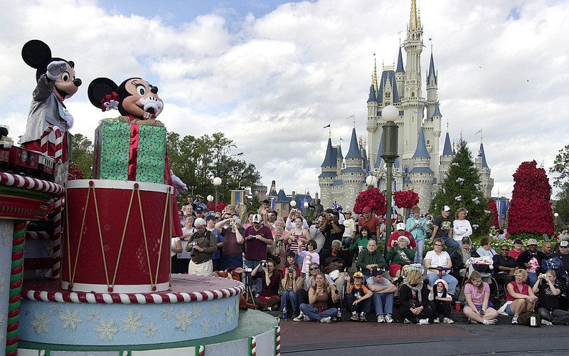 Visitors gather in front of Cinderella's castle to watch Mickey and Minnie Mouse during the Christmas parade at Walt Disney World's Magic Kingdom in Lake Buena Vista, Fla. If you're planning a multi-day trip to Disney World, you should start at least six months out, experts say.