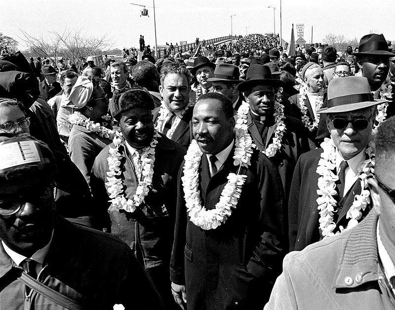 In this March 21, 1965, photo, Martin Luther King Jr. and his civil rights marchers cross the Edmund Pettus Bridge in Selma, Ala., heading for Montgomery, during a five-day, 50-mile walk to protest voting laws.