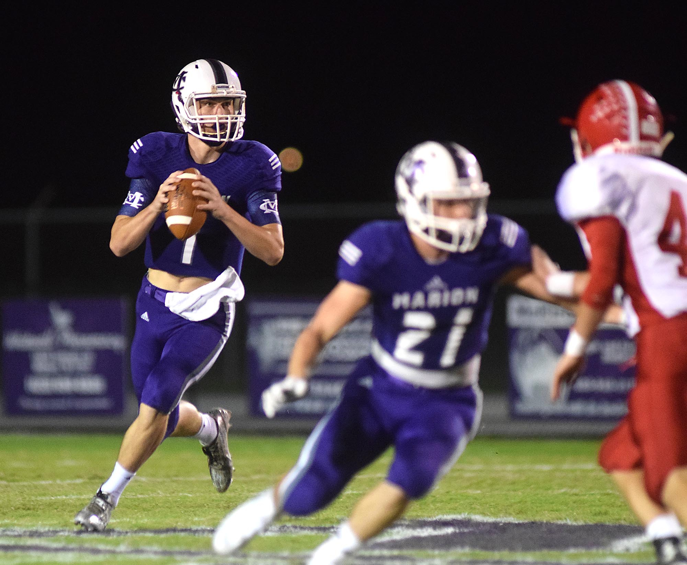 Marion County quarterback Logan Walters (1) rolls out to pass behind the blocking of Josh Henderson (21).  The Westmoreland Eagles visited the Marion County Warriors in the first round of the TSSAA football playoffs Friday night, November 6, 2015.