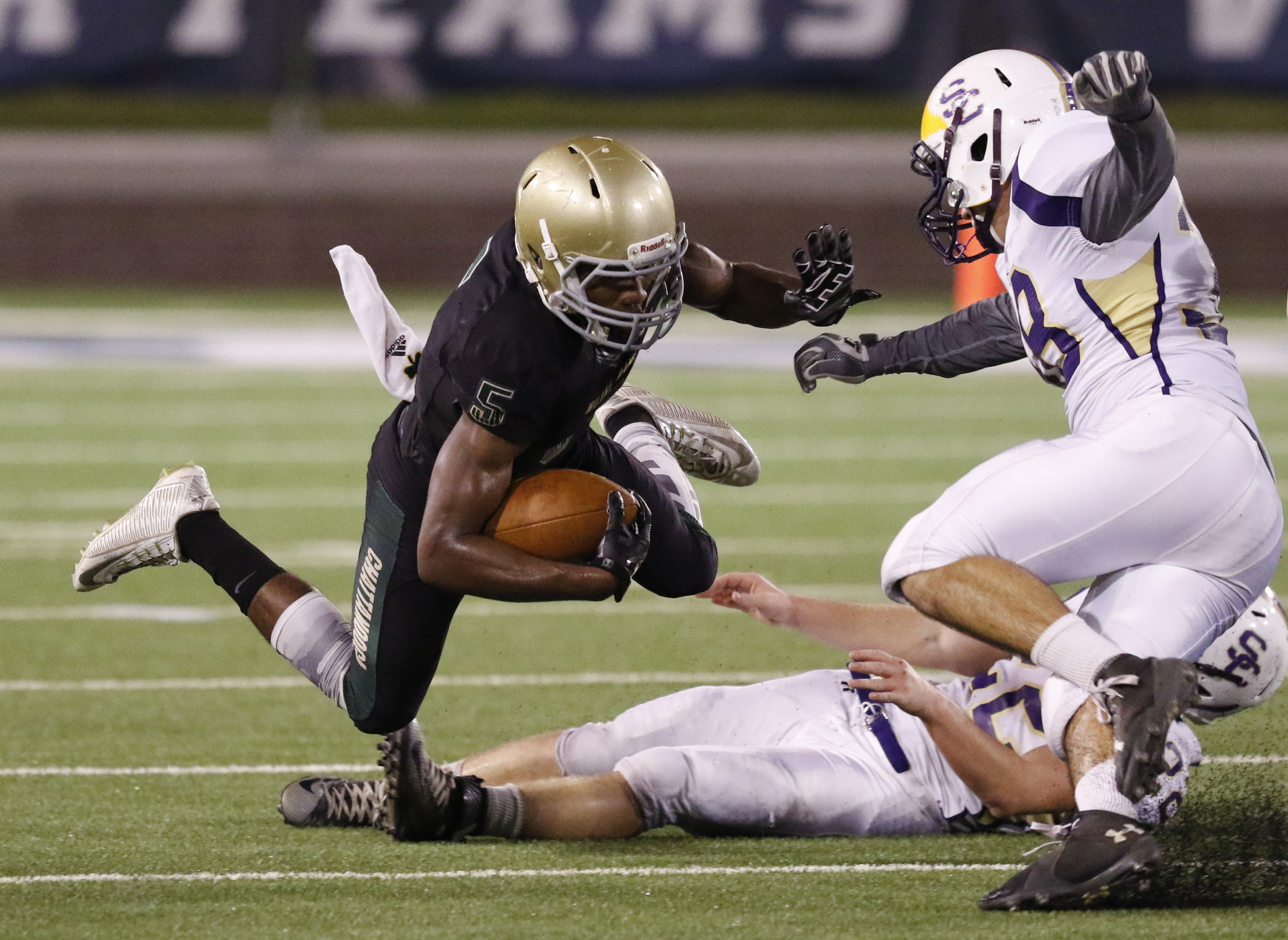 Staff Photo by Dan Henry / The Chattanooga Times Free Press- 11/6/15. Notre Dame High School's Ricky Ballard (5) dives over Sequatchie County's Caleb Reed (22) and Jacob Morgan (38) during the first half of play at Finley Stadium in downtown Chattanooga on Friday.