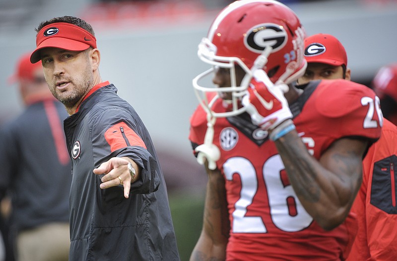 Georgia offensive coordinator Brian Schottenheimer, right, talks to Georgia wide receiver Malcolm Mitchell (26) before an NCAA college football game, Saturday, Nov. 7, 2015, in Athens, Ga. Georgia won 27-3. (AP Photo/John Amis)