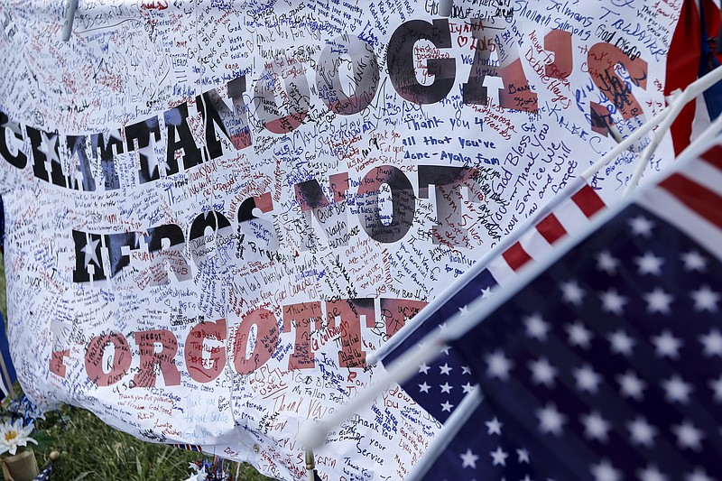 A sign, signed by supporters, is seen at a Lee Highway memorial for victims of the July, 16 shootings on Saturday, July 18, 2015, in Chattanooga, Tenn. U.S. Navy Petty Officer Randall Smith died Saturday from wounds sustained when gunman Mohammad Youssef Abdulazeez shot and killed four U.S. Marines and wounded two others and a Chattanooga police officer at the Naval Operational Support Center on Amnicola Highway shortly after firing into the Armed Forces Career Center on Lee Highway.