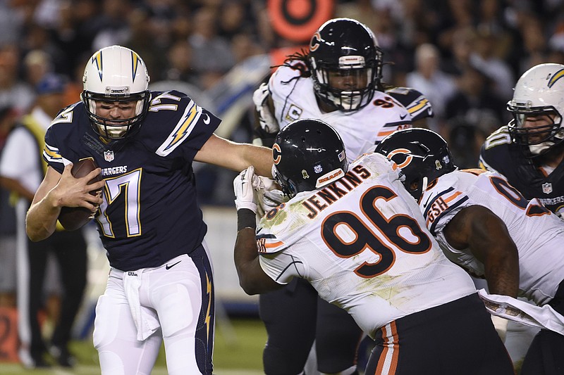 
              San Diego Chargers quarterback Philip Rivers, left, gets away from Chicago Bears defensive end Jarvis Jenkins (96) and others during the first half of an NFL football game Monday, Nov. 9, 2015, in San Diego. (AP Photo/Denis Poroy)
            
