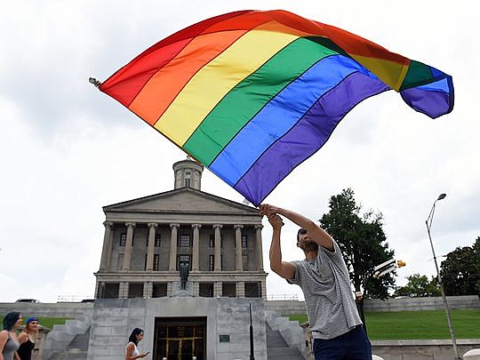 Christopher Shappley waves a gay pride flag at the Tennessee State Capitol to celebrate same-sex marriage.