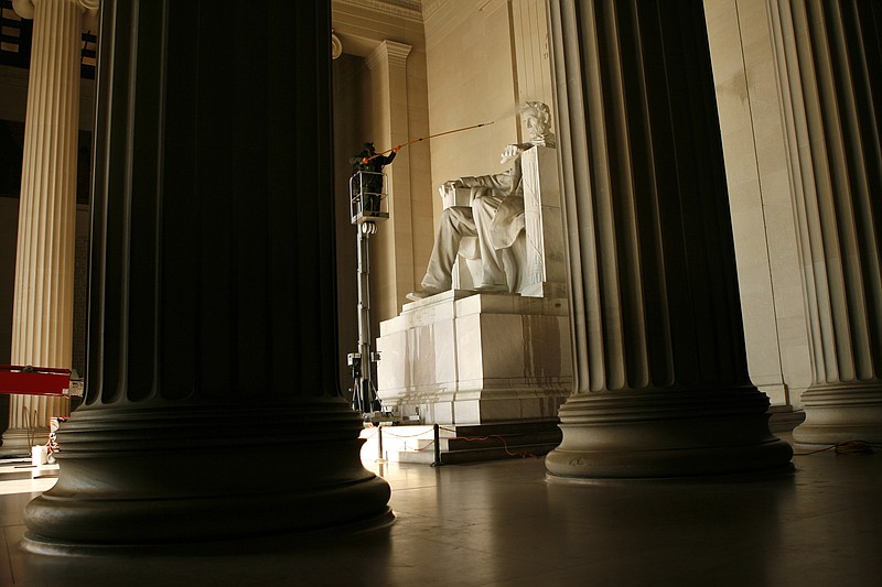 The statue of Abraham Lincoln in the Lincoln Memorial in Washington, D.C., here getting a steam cleaning, has a view of memorials honoring more than 1 million war dead.