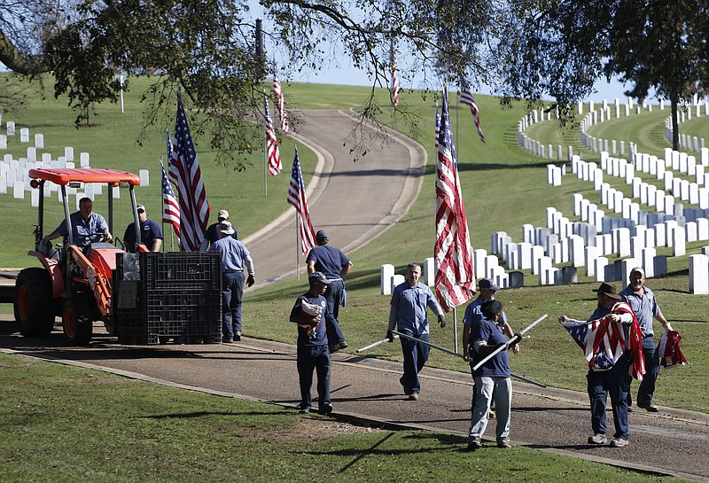 Chattanooga National Cemetery grounds workers set up flags on Tuesday in preparation for Veteran's Day festivities Wednesday.