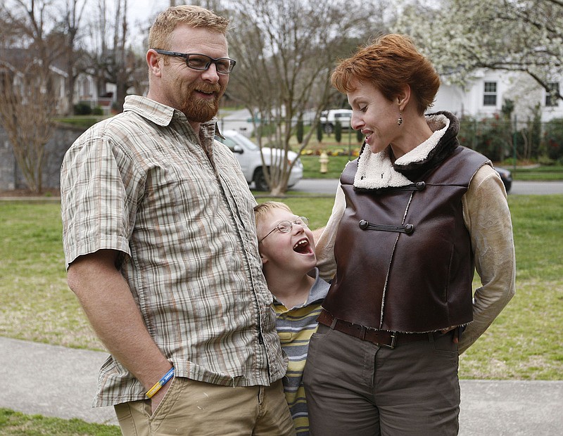 Greg Hyde, left, his wife Deborah, right, and their son Luka, 9, who has Down Syndrome, stand together at Riverview Park in Chattanooga, Tenn.