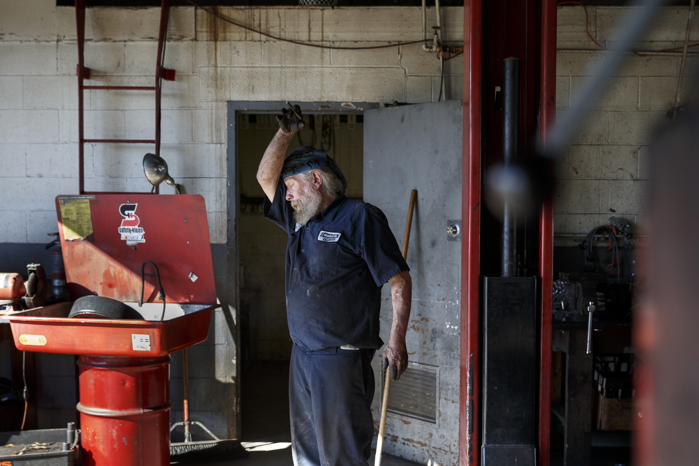 Mechanic Chip Paris wipes his forehead on his sleeve after finish a brake job at Market Street Tire & Auto on Wednesday, Nov. 11, 2015, in Chattanooga, Tenn. The business is preparing to close for 6-8 weeks before returning as a corporate Firestone Tire location.