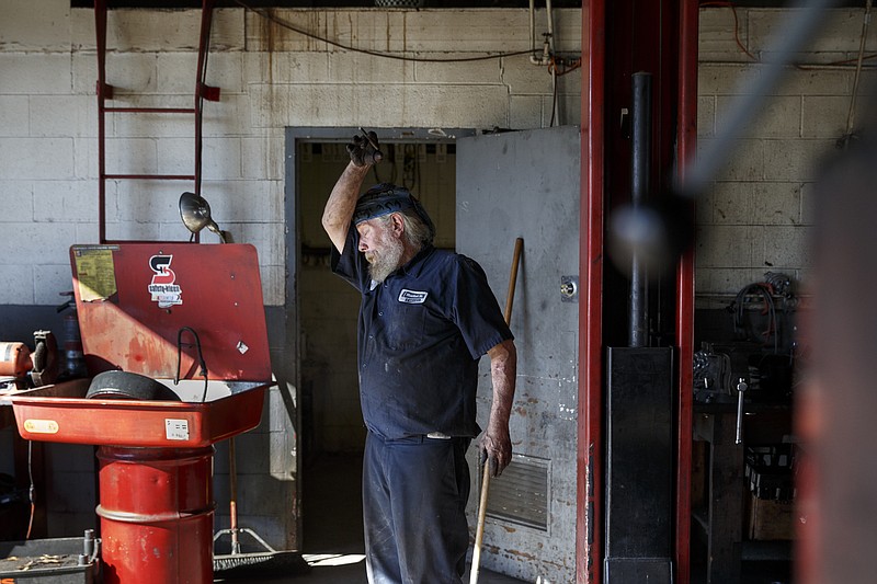 Mechanic Chip Paris wipes his forehead on his sleeve after finish a brake job at Market Street Tire & Auto on Wednesday, Nov. 11, 2015, in Chattanooga, Tenn. The business is preparing to close for 6-8 weeks before returning as a corporate Firestone Tire location.