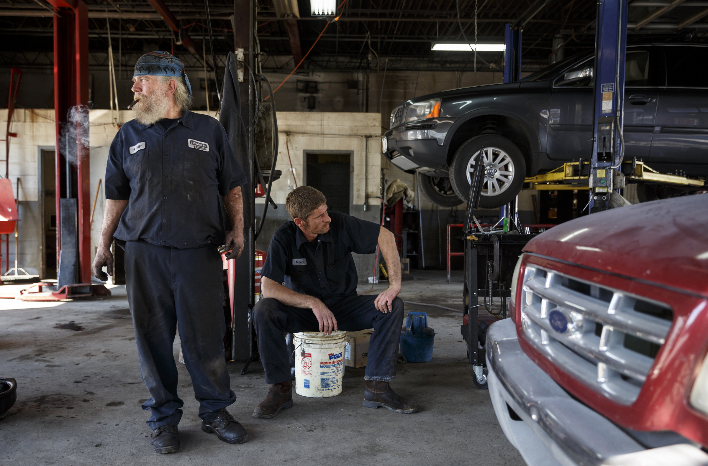 Mechanics Chip Paris, left, and Travis Brown sit in the shop between jobs at Market Street Tire & Auto on Wednesday, Nov. 11, 2015, in Chattanooga, Tenn. The business is preparing to close for 6-8 weeks before returning as a corporate Firestone Tire location.