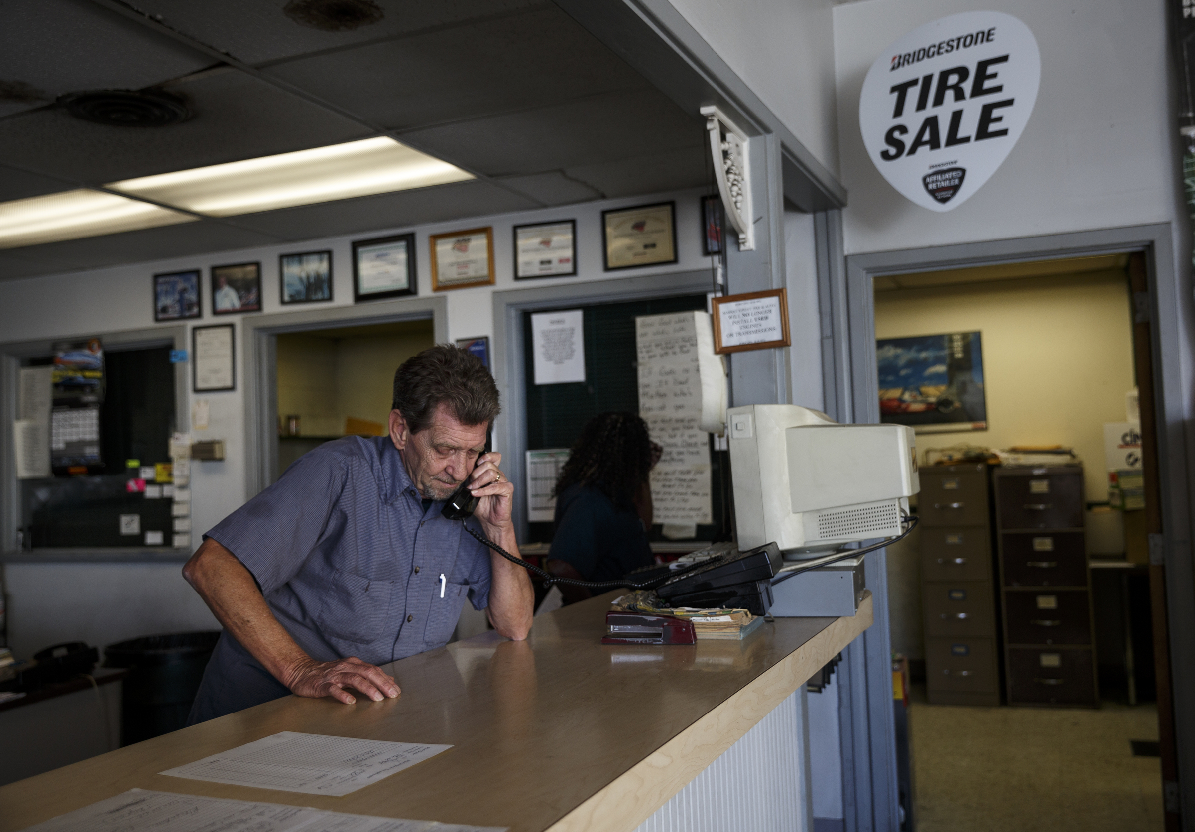 Manager Randy Keith takes a sales call from the front desk at Market Street Tire & Auto on Wednesday, Nov. 11, 2015, in Chattanooga, Tenn. The business is preparing to close for 6-8 weeks before returning as a corporate Firestone Tire location.