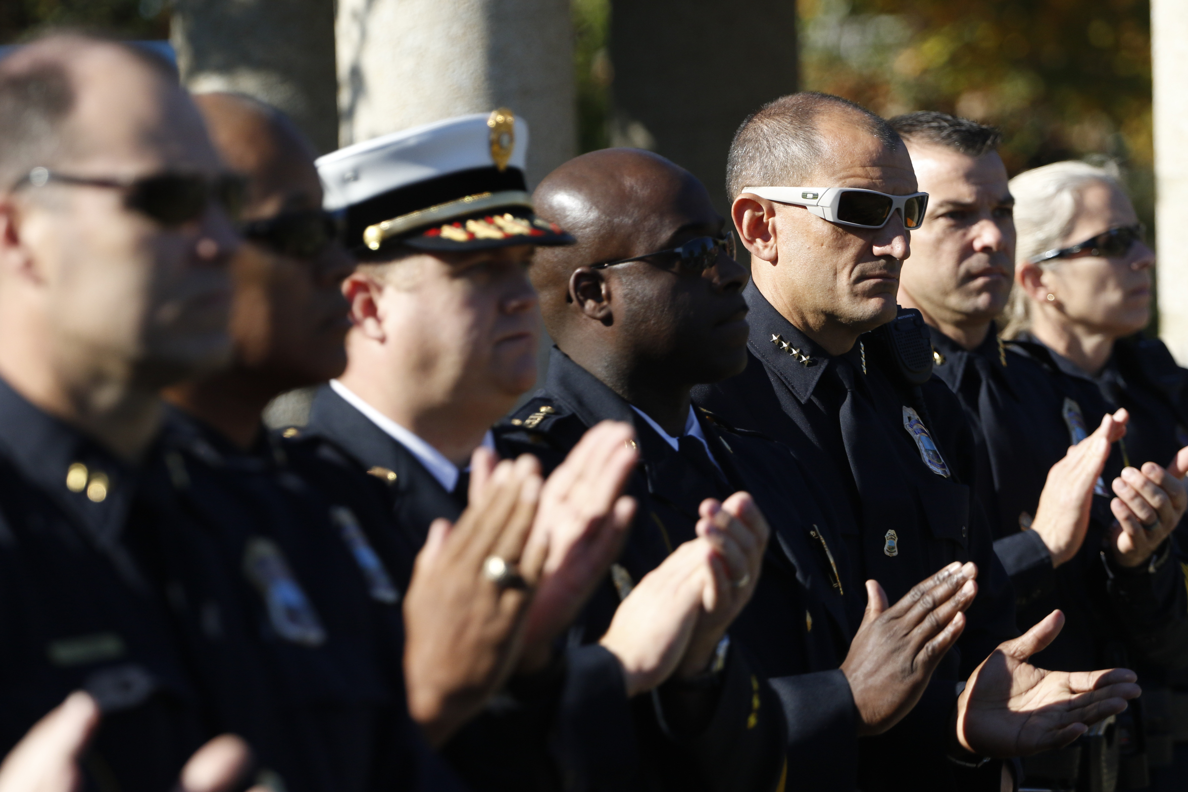 Staff Photo by Dan Henry / The Chattanooga Times Free Press- 11/11/15. Chattanooga Police Chief Fred Fletcher and other officers applaud as Chattanooga Mayor Andy Berke speaks to patriots and officials during a flag raising ceremony in the Bluff View River Gallery Sculpture Garden in honor of Veterans Day on Wednesday, November 11, 2015. Five flags will be permanently flown on Veteran's Bridge in honor of the military personnel lost earlier this year.