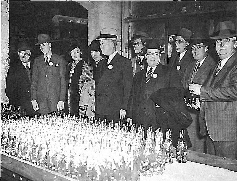Charles Saylor, second from left, who was personnel manager at Chattanooga Glass Co., and visitors inspect the latest production run of Coca-Cola bottles.