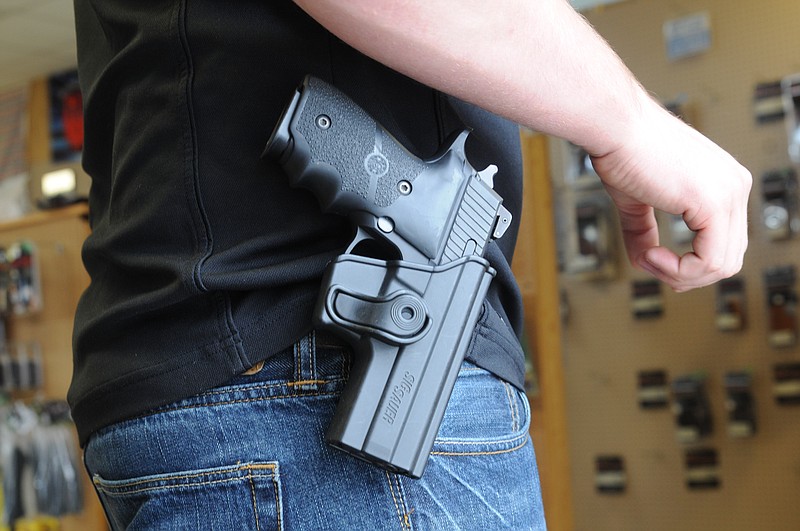 A man wears a Ruger LCR, 9mm, firearm on his hip.