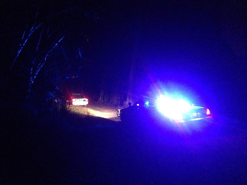 Police cars are seen near the Bradley County home where two people were found dead Thursday night.