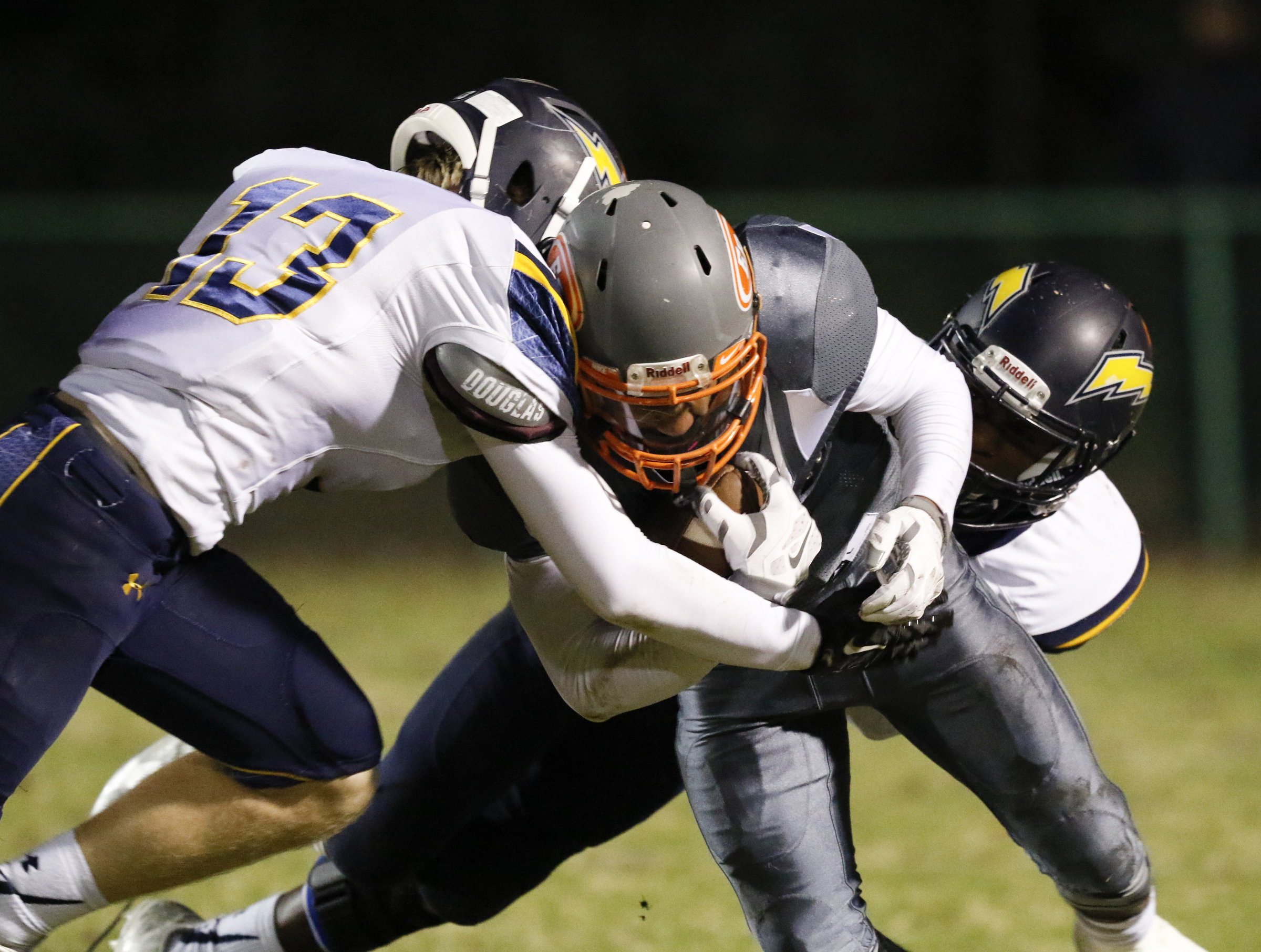 *Staff Photo by Dan Henry / The Chattanooga Times Free Press- 11/13/15. East Ridge's Jesse Jones (11) is hit by Chattanooga Christian's Gaines Tallent (13) and Brandon Mason (4) during the first half of play at the Pioneer's home field on Friday, November 13, 2015.