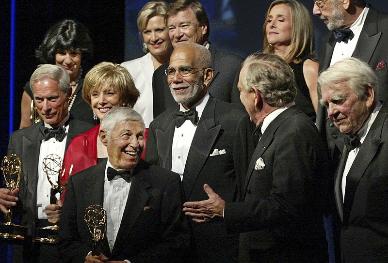 
              FILE - In this Sept. 3, 2003 file photo, Ed Bradley, center, stands with past and present correspondents of "60 Minutes" and Don Hewitt, the executive producer, lower left, on stage for a Lifetime Achievement Award at the annual News and Documentary Emmy Awards in New York. A stretch of road in Philadelphia is being renamed for late "60 Minutes" correspondent Bradley, who began his broadcasting career in the city. A spokeswoman for KYW-TV said a portion of City Avenue between Monument Road and Presidential Boulevard is to be dedicated as Ed Bradley Way during a Saturday, Nov. 14, 2015 ceremony. (AP Photo/FILE/Stuart Ramson, File)
            