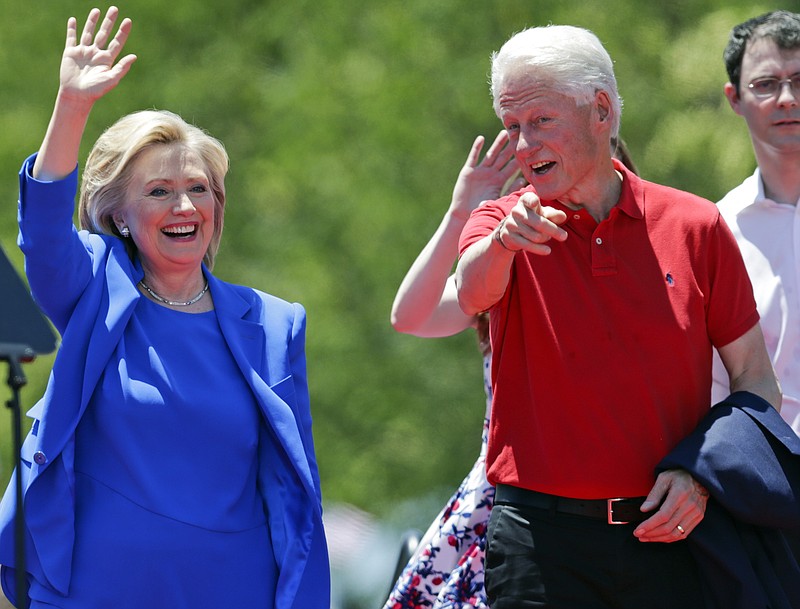 In this June 13, 2015, file photo, Democratic presidential candidate, former Secretary of State Hillary Rodham Clinton, and her husband, former President Bill Clinton, gesture to supporters on Roosevelt Island in New York.