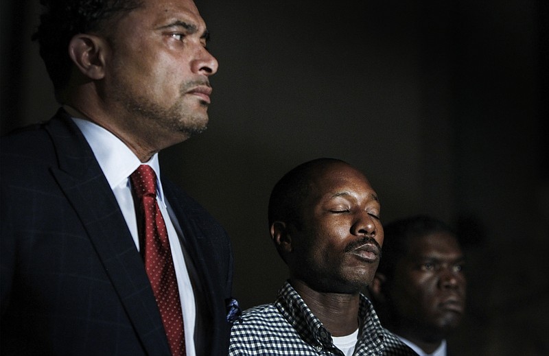 While surrounded by his attorneys Arthur Horne, left, and Juan Williams, right, Henry Williams attends a news conference after a grand jury declined to indict Memphis Police Officer Connor Schilling in the shooting death of his son Darrius Stewart, Tuesday, Nov. 3, 2015, in Memphis.