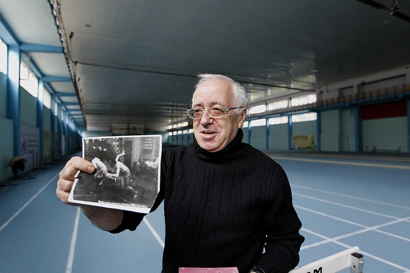 
              Associated Press  correspondent Misha Dzhindzhikhashvili holds a 1970 photo, showing him running during the All-Union track-and-field youth competitions in Leningrad, now St. Petersburg, Russia, in Tbilisi, Georgia, Monday, Nov. 16, 2015. Dzhindzhikhashvili who has been the Georgia correspondent for The Associated Press since 1992, had a close call with doping in the Soviet Union in 1967, when he was 17 and had just returned home from training camp. His new trainer suggested he start taking anabolic steroids to put on the muscle mass he needed to get up to speed more quickly. He refused the offer.  (AP Photo/Shakh Aivazov)
            