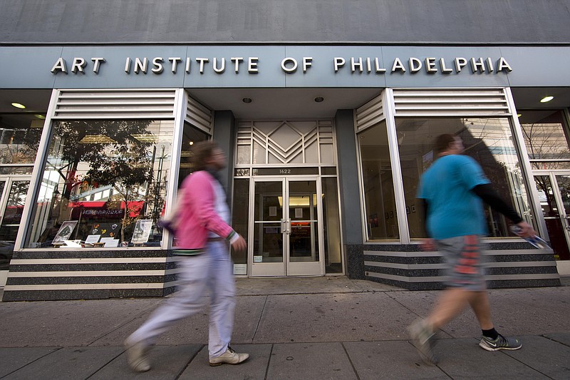 
              People walk past the Art Institute of Philadelphia operated by the Education Management Corporation on Monday, Nov. 16, 2015, in Philadelphia. The Obama administration has reached a $95.5 million settlement with a Pittsburgh firm that runs for-profit trade schools and colleges. The Justice Department settlement resolves allegations that Education Management Corporation used enrollment incentives to pay its recruiters and exaggerated its career-placement ability. (AP Photo/Matt Rourke)
            