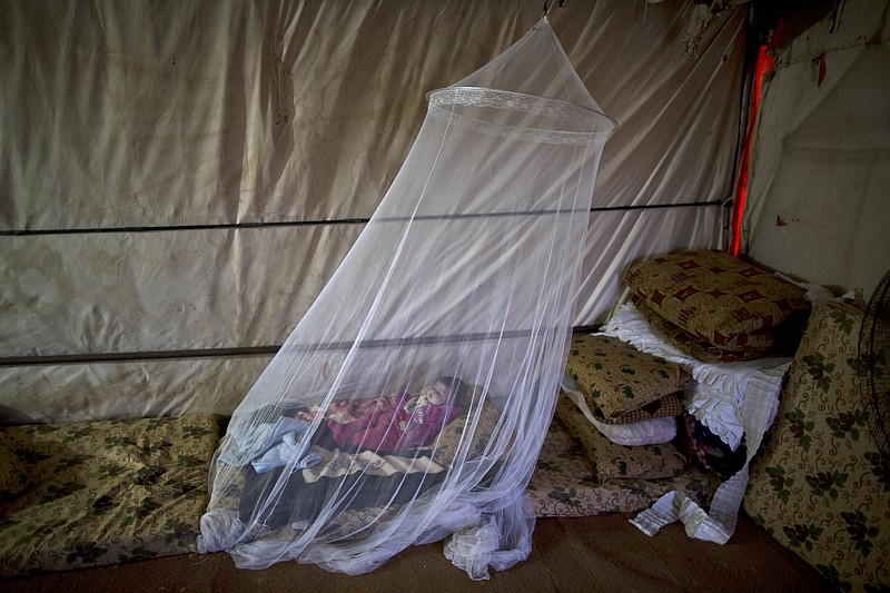 
              FILE - In this Wednesday, Oct. 18, 2015 file photo, Syrian refugee Zahra Saad, who is nearly four months old, lies on the ground underneath a mosquito net at her family's tent in an informal settlement near the Syrian border on the outskirts of Mafraq, Jordan. Bold ideas for helping Syrian refugees and their overburdened Middle Eastern host countries are gaining traction among international donors, who were shocked into action by this year's migration of hundreds of thousands of desperate Syrians to Europe. (AP Photo/Muhammed Muheisen, File)
            