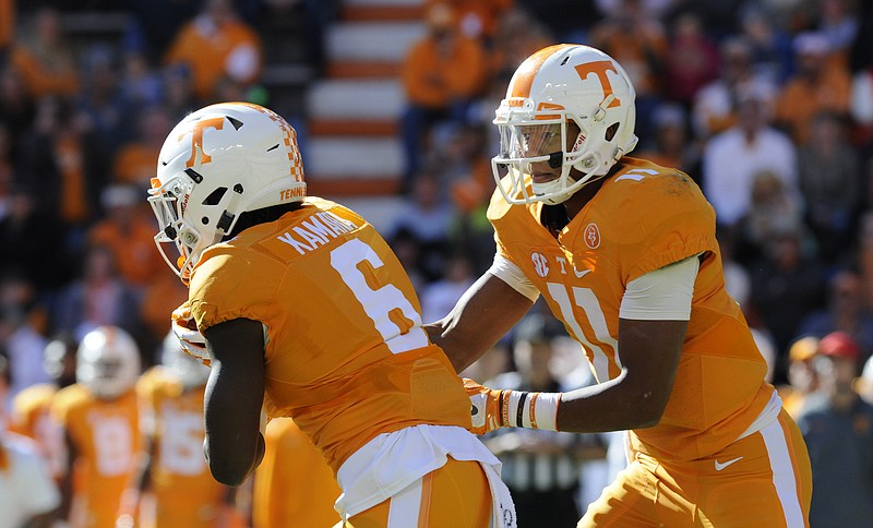 Tennessee quarterback Joshua Dobbs, right, gives the ball to Alvin Kamara in second half action Saturday in Knoxville.