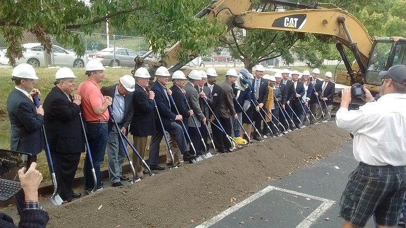 Officials line up to shovel dirt at Tuesday's groundbreaking ceremony for a new west campus dorm on Vine Street.