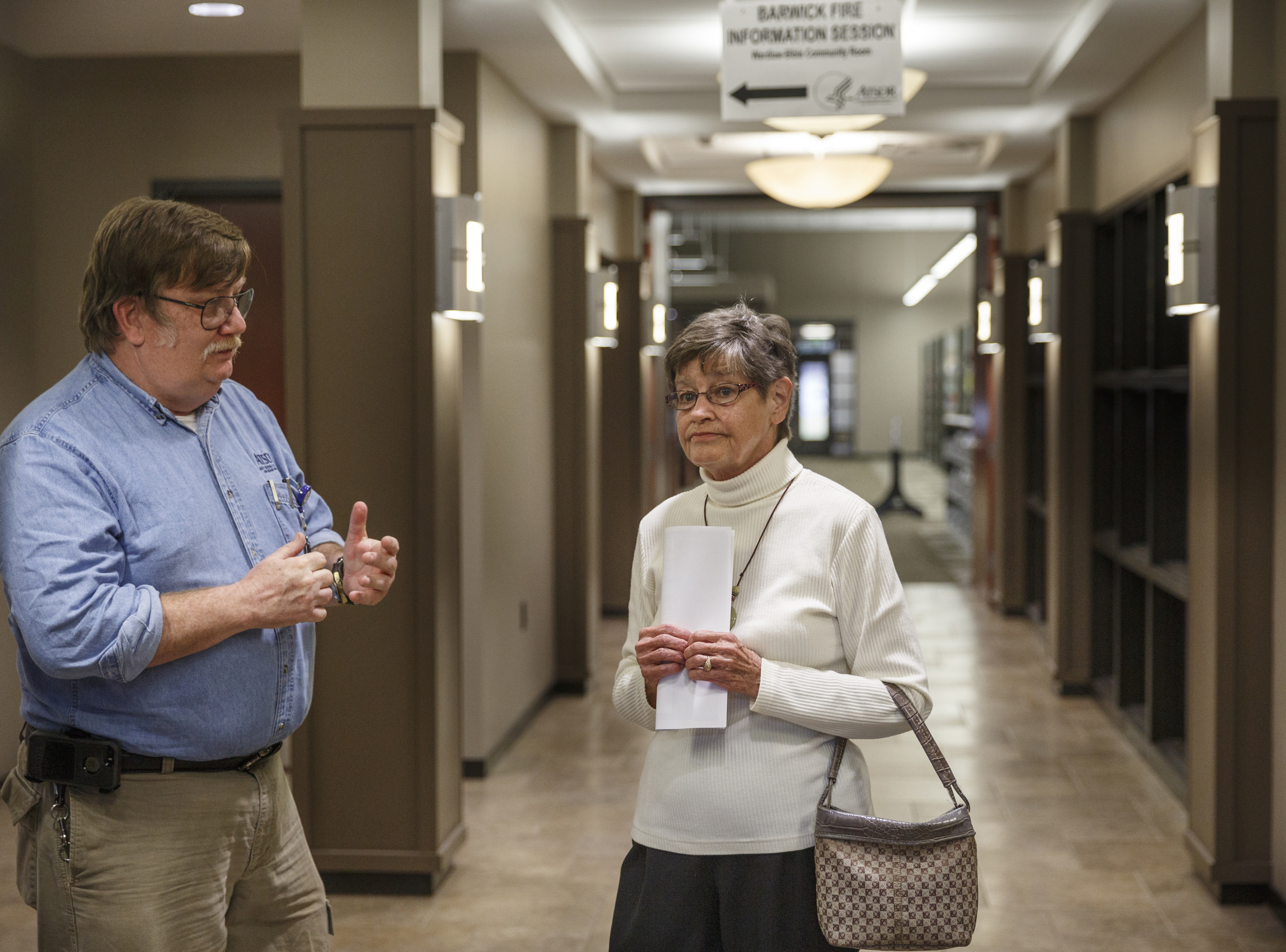 Environmental health scientist Rich Nickel with the Agency for Toxic Substances and Disease Registry, left, talks with resident Faye Russell during an informational session at the Lafayette Walker-County Library on Tuesday, Nov. 17, 2015, three days after a fire destroyed much of the Barwick Mills building in Lafayette, Ga. The EPA has been taking air samples to assess the impact of the fire.