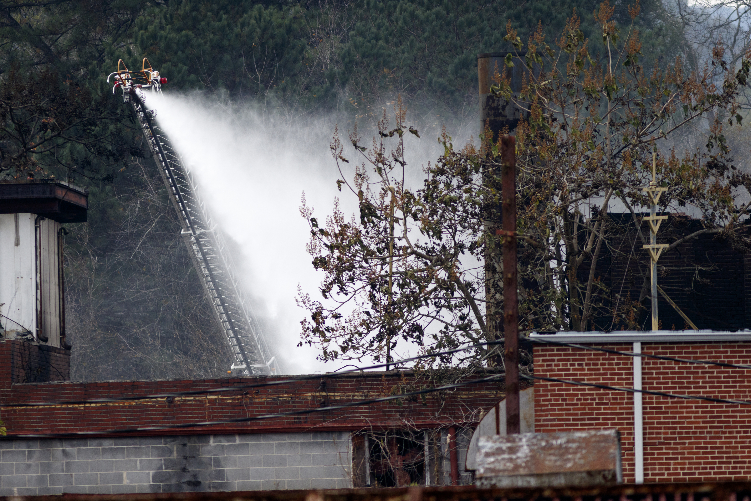 Water is sprayed on the burned wreckage of the Barwick Mills building Tuesday, Nov. 17, 2015, three days after a fire destroyed much of the building in Lafayette, Ga. The EPA has been taking air samples to assess the impact of the fire.